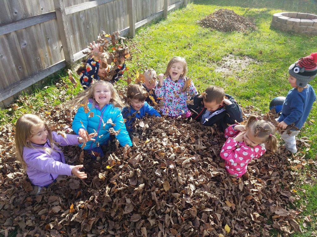 kids playing in leaves at Lauras daycare in Eagan MN