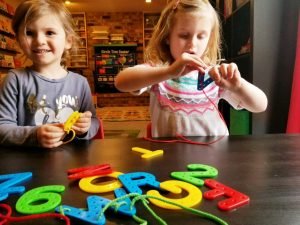 two girls practicing their letters during their preschool day