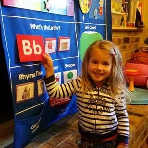 Child practicing their letters and numbers on the learning chart